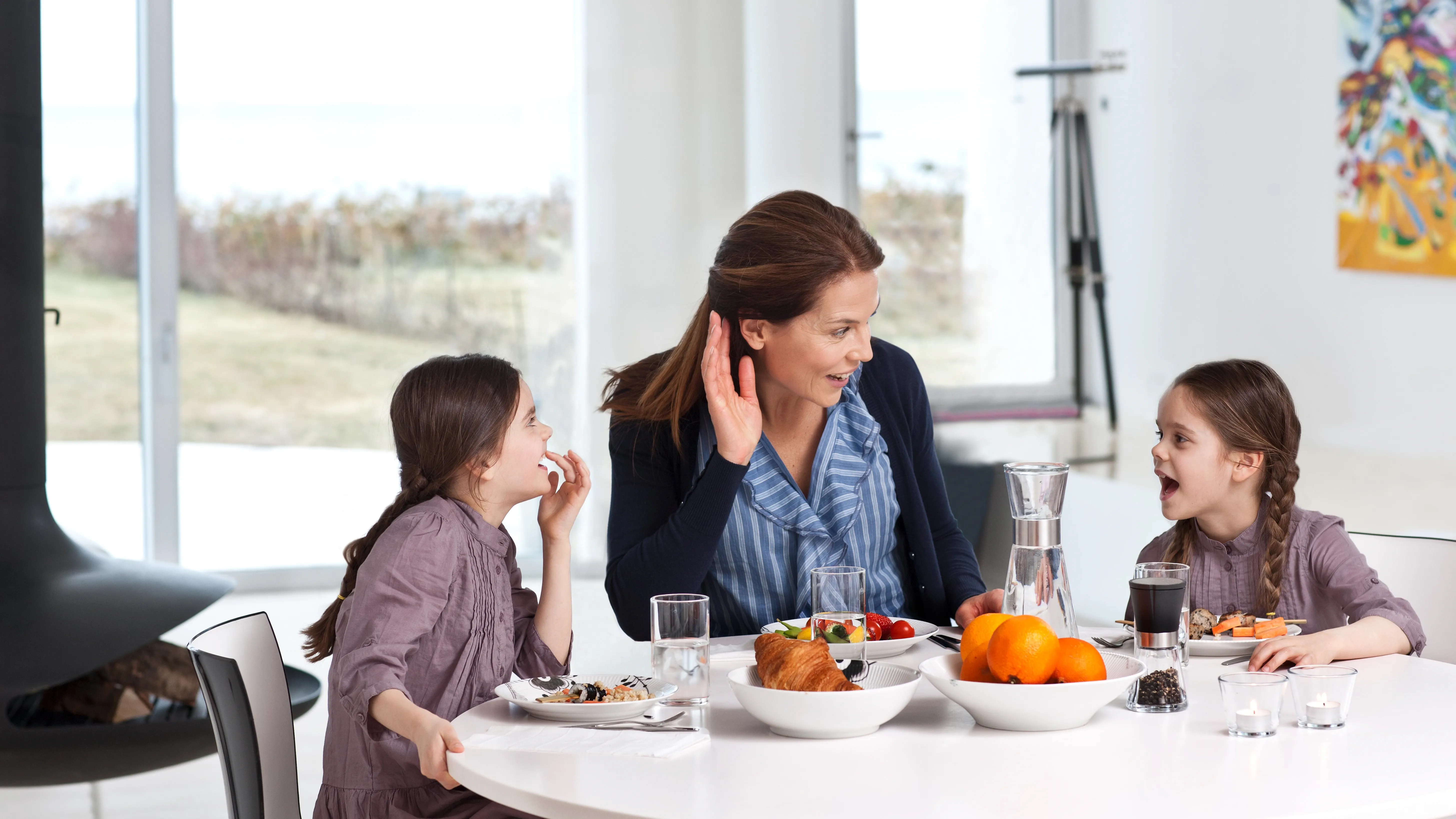Mother spending time with her two daughters wearing hearing aids